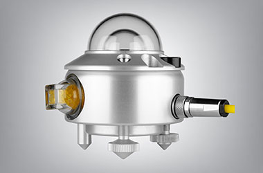 A Kipp & Zonen ISO Class B pyranometer, a small silver instrument with a double glass dome on the top, yellow desiccant cartridge attached on one side, and a yellow cable extending from its other side.
