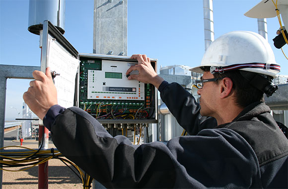 A site technican adjusting controls on a data logger.