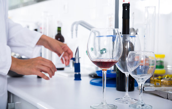 a winemaker quality testing wine at a lab