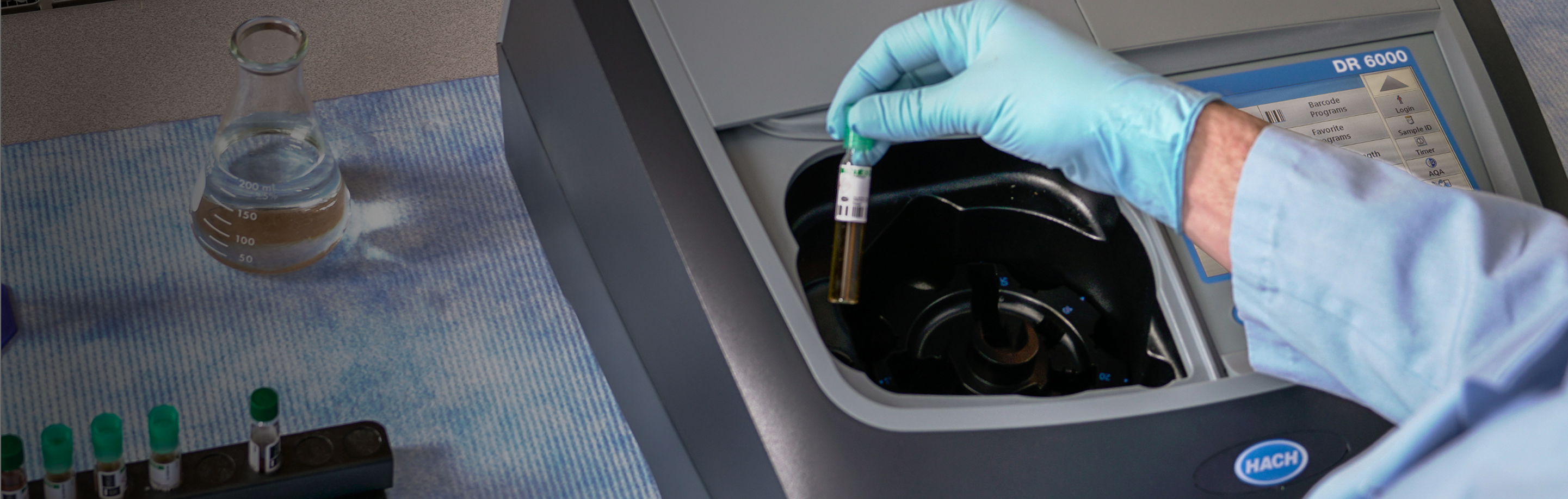 Picture of a tech's hand taking a vial out of a Hach DR 6000 Spectrophotometer