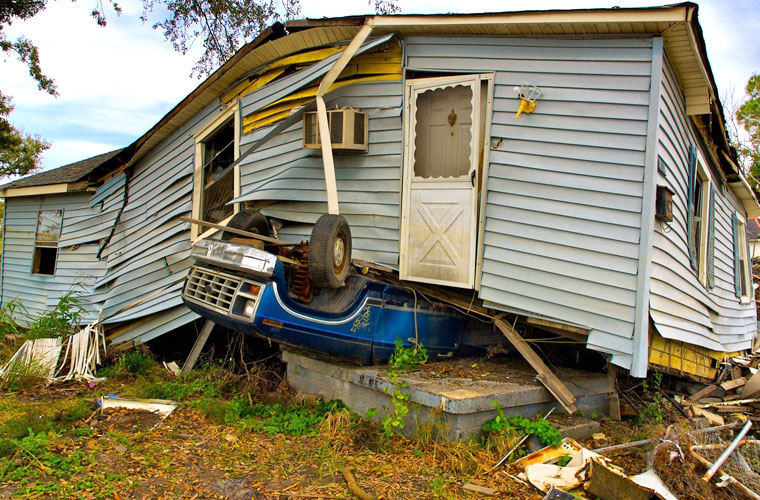crashed car and house after a hurricane