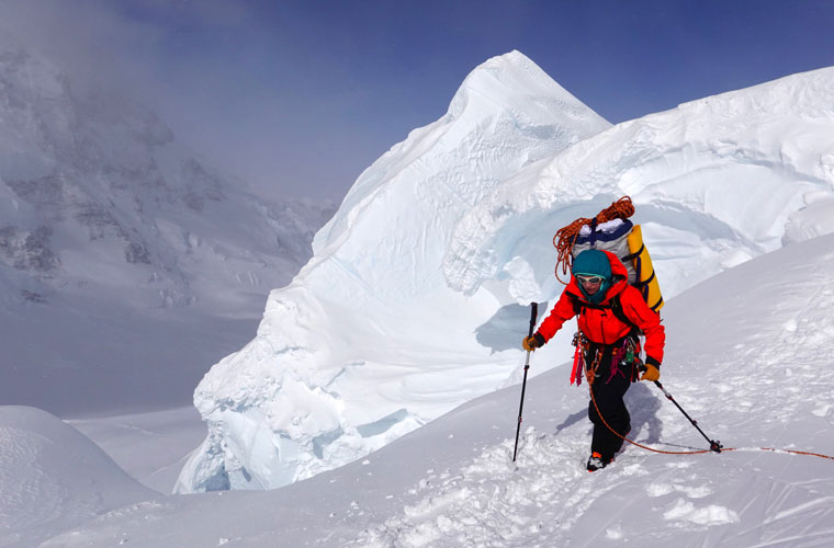 A scientist with a backpack climbing up to a monitoring station on Mount Logan in Canada.