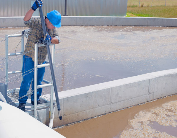 Wastewater plant operator monitoring dissolved oxygen in water for precise aeration control