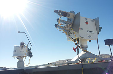 A Kipp & Zonen SOLYS2 Sun Tracker aimed skyward under a blue sky with another Kipp & Zonen instrument in the background.